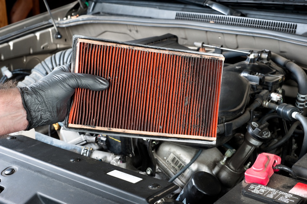 一般汽车维护期间，一款汽车机械机械佩戴防护工具持有脏污，堵塞的空气过滤器。